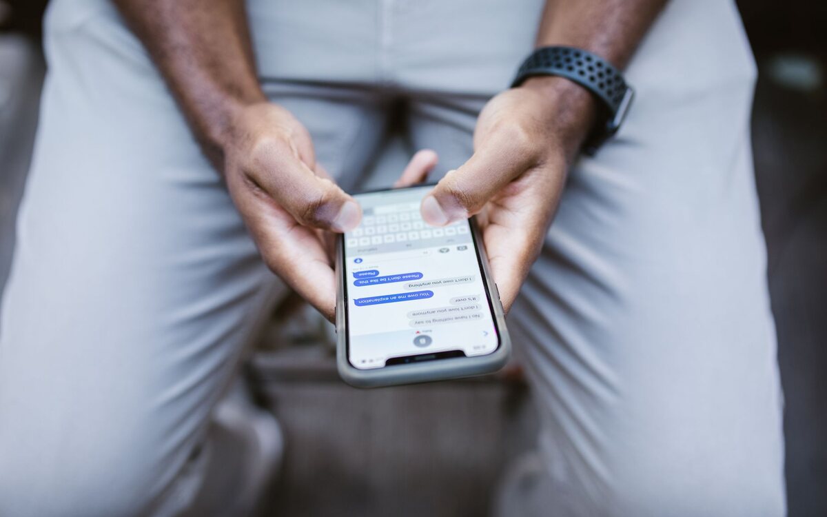 Hands holding a phone during a messaging conversation